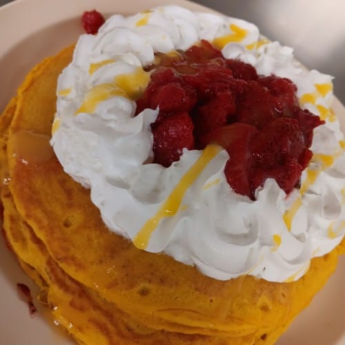 Two Hot Cakes with Strawberries and Whipped Cream.