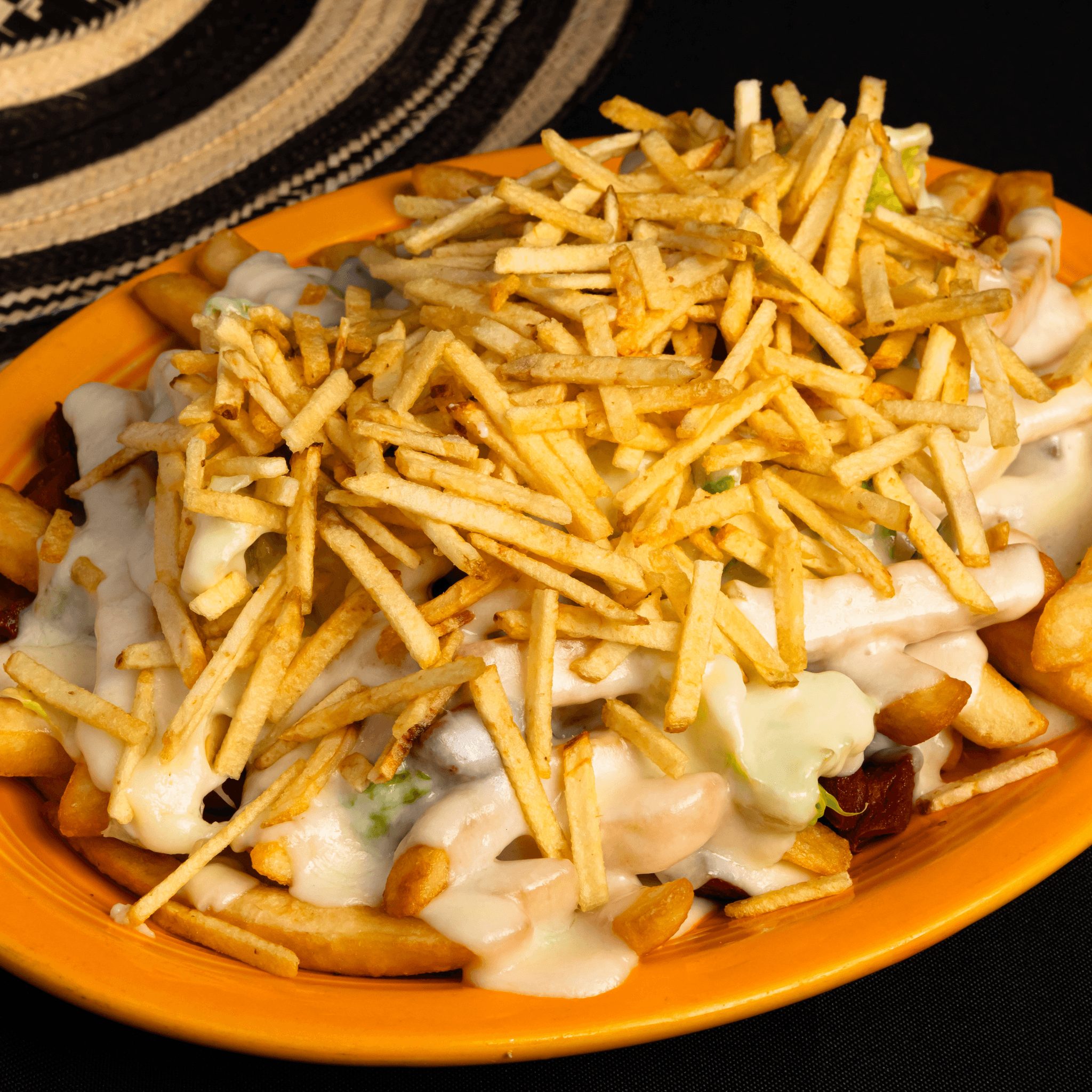 Salchipapa Costena con Queso y Salsas.