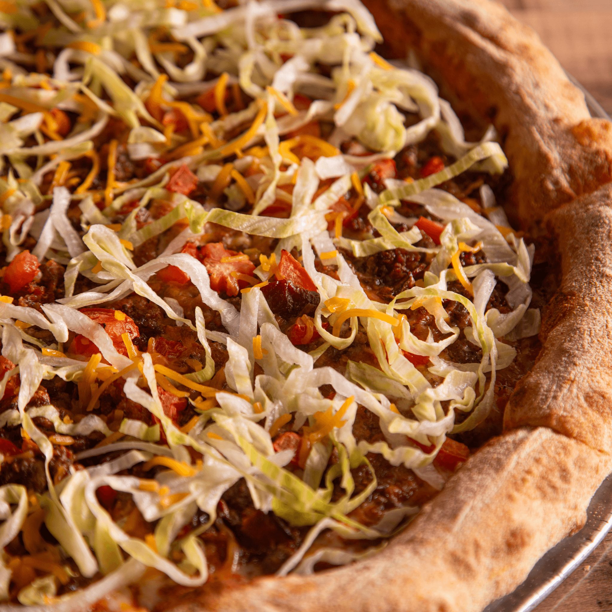 Bacon double cheeseburger pizza slice.