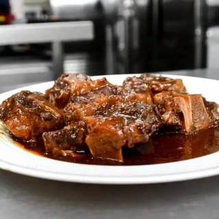 Oxtails Served with White Jasmine Rice Cabbage and Plantains