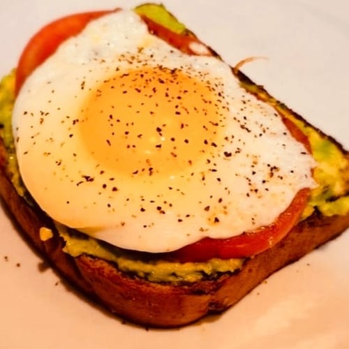 Avocado Toast, fried egg & grilled tomato.