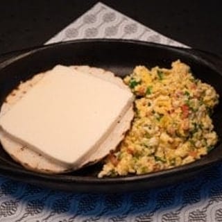 Huevos revueltos con arepa y queso / scrambled eggs with a corn cake and cheese