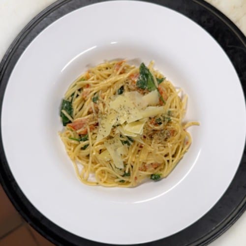 Spaghetti with spinach and sun-dried tomatoes in cream sauce.