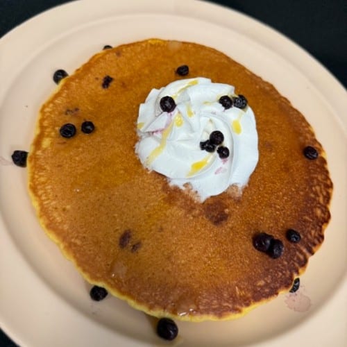 Two Hot Cakes with Blueberries and Whipped Cream.